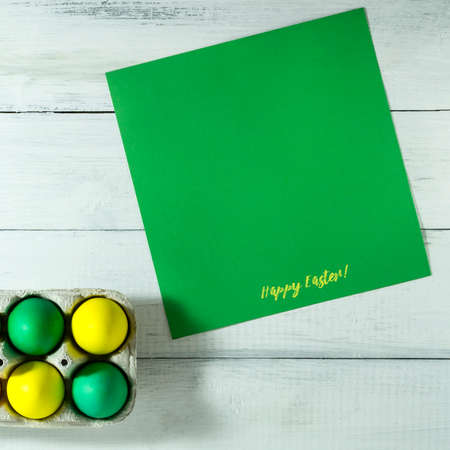 Easter eggs in a tray on a white wooden background. Top view with copy space