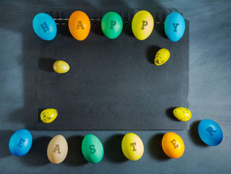 Easter composition with colorful eggs on a dark blue background.Top view with copy spaceの写真素材