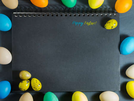 Easter composition with colorful eggs on a dark blue background.Top view with copy spaceの写真素材