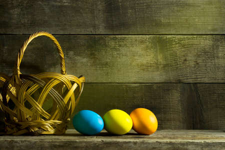 Easter still life with colorful eggs on an old wooden background with copy space
