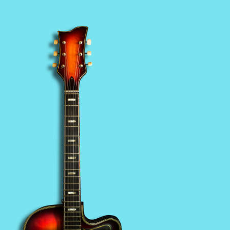 Old electric guitar, on a blue background. Background for festivals, concerts. Copy space. Musical...