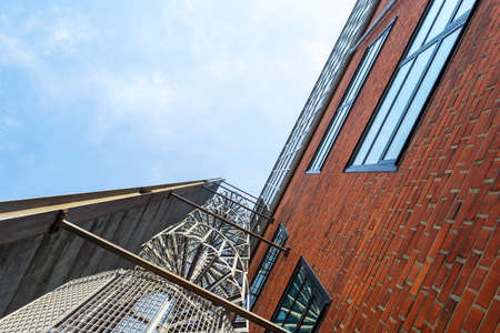 Malmo. Sweden. July 29, 2019 Metal spiral staircase on the facade of a brick building. Urban modern...