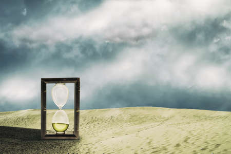 Hourglass in the sand dunes. Cloudy sky. Time concept. Business. Lifestyle. Abstraction background.