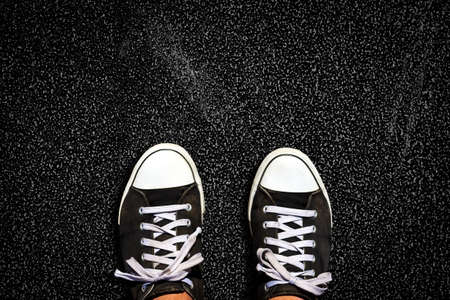 Sneakers on the asphalt road. View from above. Copy space. Lifestyle, travel, business concept. Background.の写真素材