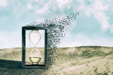Hourglass falls apart in the sand dunes. dispersion effect. The concept of the passing time. business. lifestyle. background.の写真素材