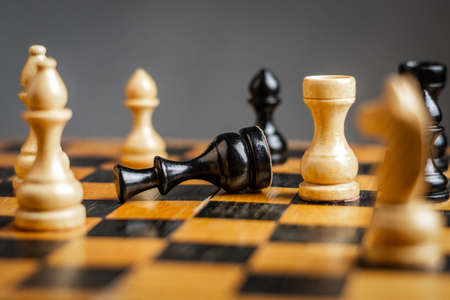 Black king lies on the chessboard. selective focus. Defeat. Bad strategy concept. sport. business. background.の写真素材