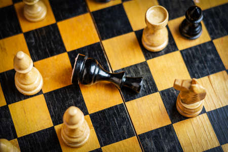 Black king lies on the chessboard. selective focus. top view. Defeat. Bad strategy concept. sport. business. background.の写真素材