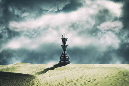 Chess black queen in the sand dunes. cloudy sky. leadership concept. success. abstraction. business. background.の写真素材