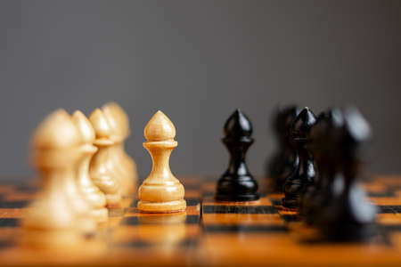 White pawn, in front of black, on a chessboard. Selective focus. Correct move. Strategy. Sport. Business Backgroundの写真素材