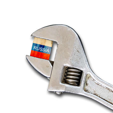 Flag of Russia on a wooden block, clamped with a wrench. isolated on white background. sanctions. country isolation. economic blockade. economy. politics. conflict.の写真素材