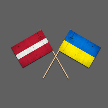 Flags of Latvia and Ukraine, on wooden sticks. Isolated on a gray background. International political relations. Commonwealth. Support. Political Economicの写真素材