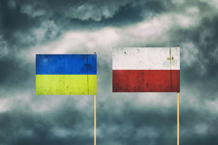 Flag of Ukraine and Poland. Cloudy sky. Politics. Economyの写真素材