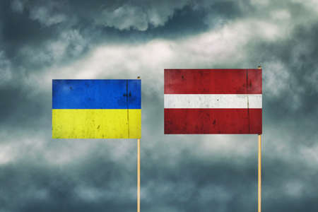 Flag of Ukraine and Latvia. cloudy sky. politics. economy backgroundの写真素材
