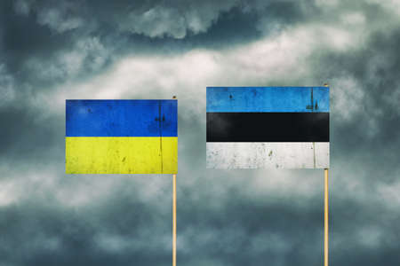 Flag of Ukraine and Estonia. cloudy sky. politics. economy backgroundの写真素材