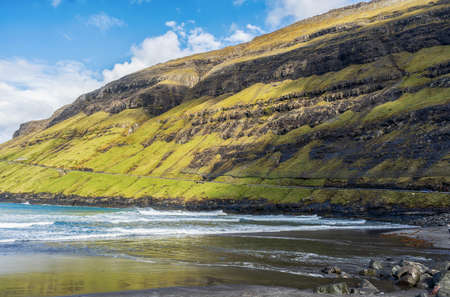 Road near the beautiful mountains, and the sea bay. Faroe Islands. Denmark, Europe. landscapes. Nature. travel concept backgroundの写真素材