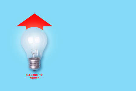 Rising electricity prices.Bulb, and arrow up, on a blue background.Copy space. world crisis. business. economics.の写真素材