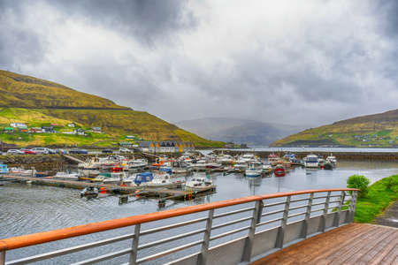 Boats parked in the bay, among the beautiful mountains. Clouds, fog. Faroe islands. Denmark. Europe.Transport. Water transport Landscapes Natureの写真素材