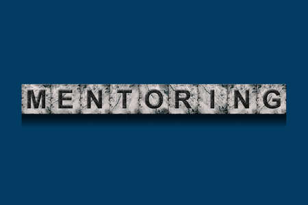 mentoring. Word on stone blocks. Isolated on dark blue background. design element. business. background.の写真素材