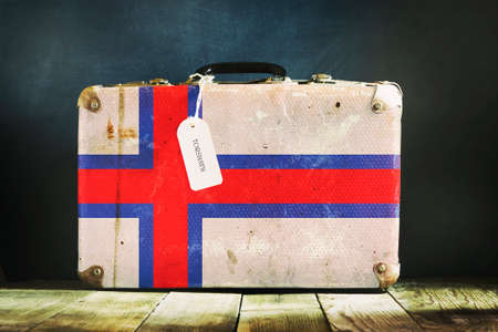Old suitcase in the colors of the Faroe Island flag. Travels. Signs and symbols. background.の写真素材