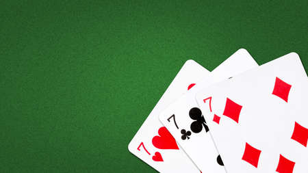 Three sevens, on a green background. copyspace. gambling backgroundの写真素材