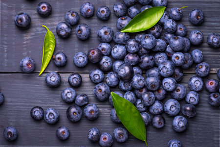Blueberries with green leaves, on a dark blue wooden background. Close-Up. Healthy food. Diet. Top view. Berries.の写真素材