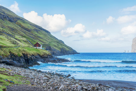 Risin and Kellingin rocks. Sea bay, among beautiful mountains, and beautiful clouds in the blue sky.Tijornuvik bay on Streymoy island. Faroe Islands. Denmark. Europe. Landscapes. Nature.の写真素材