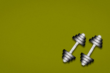 Two dumbbells on a green background. Top view. Copy space. Place for text. Sports equipment, gym, fitness. Sports background.の写真素材