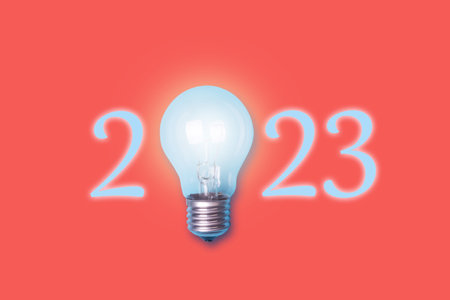 2023. Numbers and a glowing light bulb on an orange background. The concept of new ideas in the New Year. Holidays. Background.の写真素材