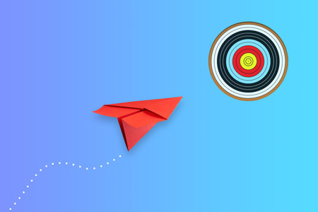Red paper plane flies to the target, on a blue background. The concept of achieving the goal. success. Business. Lifestyle. Background.の写真素材