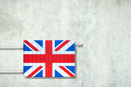 Heating battery, in the colors of the England flag on a concrete wall. Copy space. Raising heating prices. Heat saving. Energy crisis. Background.の写真素材