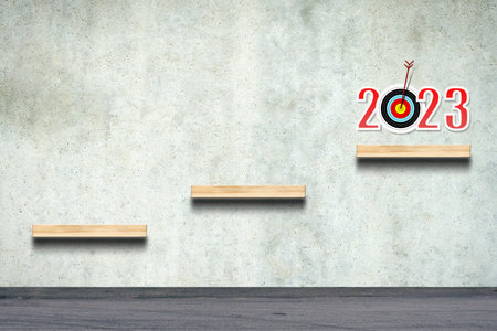 2023. Numbers, target, and stairs on a concrete wall. Copy space. Achievement of the goal, and...