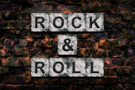 Rock and Roll. Words on stone blocks, on old vintage bricks wall. Direction in music. Musical style. Design element.の写真素材