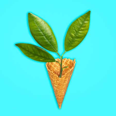 Young seedling in an ice cream cone, on a blue background. Isolated. Ecology concept. Natural products. Ecological products.の写真素材