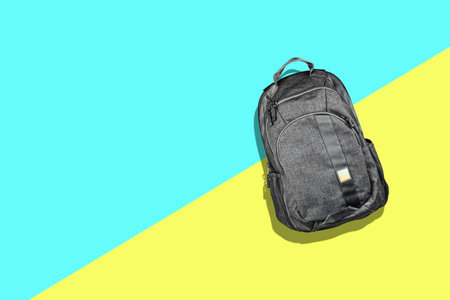 Gray fabric backpack. On a blue yellow background. Minimalism. Travel concept. Accessories. Fashion.