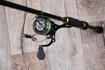 Spinning rod with reel on a gray wooden background. Copy space. Fishing background.の写真素材