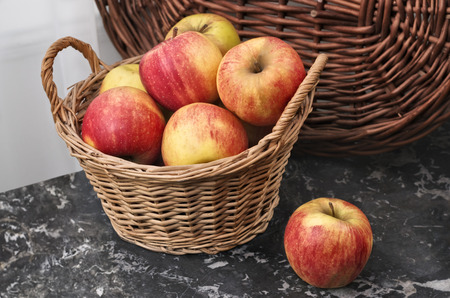 Wicker basket with fresh picked ripe apples  の写真素材