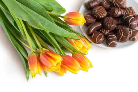 Bouquet of tulips and chocolate candies on white background. Selective Focus.の写真素材