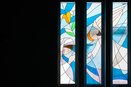 Modern styled stained glass windows with predominantly blue colors, in church, with angels, mid range viewの写真素材