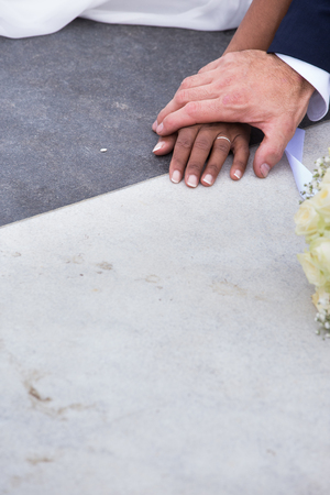 bride and groom of different ethnicities, holding hands, close upの写真素材