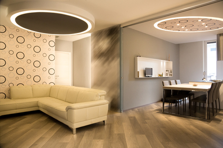 modern living room and kitchen separated by open sliding wall, warm colorsの写真素材