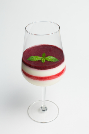 Panna cotta layered with different kind of berries jam, leaves of mintの写真素材