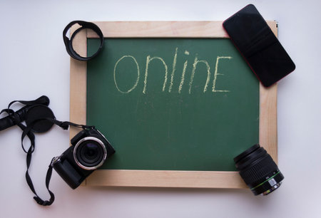 on line written on a chalkboard with camera and wristwatchesの写真素材
