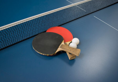 Table tennis racket and ball on blue table, closeup of photoの写真素材