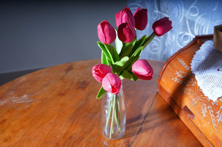 Bouquet of tulips in a vase on a wooden tableの写真素材
