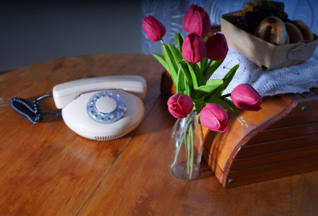 Bouquet of tulips and old telephone on a wooden tableの写真素材