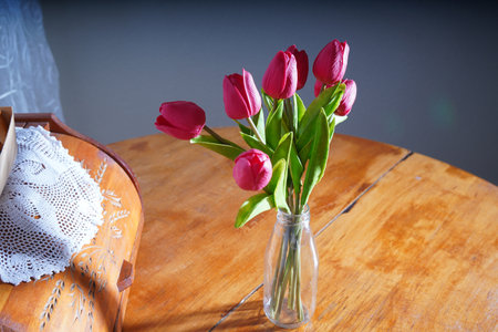 Bouquet of tulips in a vase on a wooden tableの写真素材