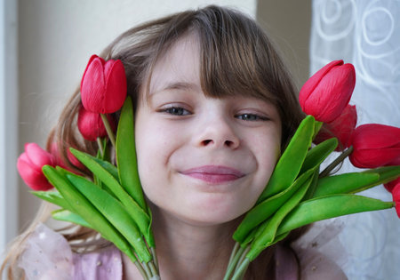 Little girl with a bouquet of tulips in her hands.の写真素材
