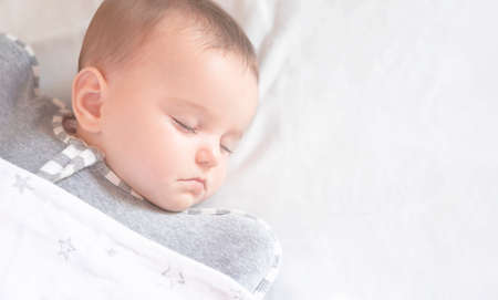 cute little baby sleeps on a white backgroundの写真素材
