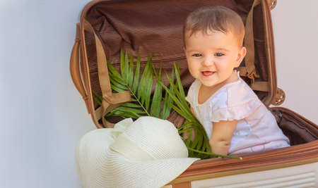 cute baby traveler sits in a suitcase. smiling child is ready to travel.の写真素材