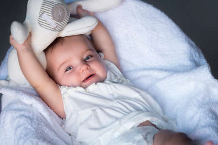 Baby plays with a toy rabbit on a white background. 5 months oldの写真素材